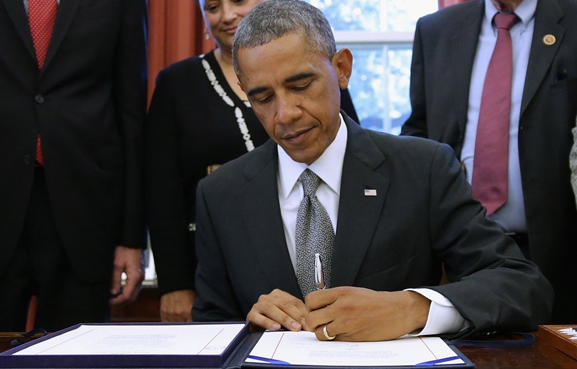 O presidente dos Estados Unidos, Barack Obama assina documento no Salão Oval da Casa Branca (Getty Images)