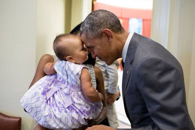Presidente Barack Obama cumprimenta a filha de Tim Gronniger, Josephine Gronniger, durante foto em família no Salão Oval da Casa Branca - 17/07/2015