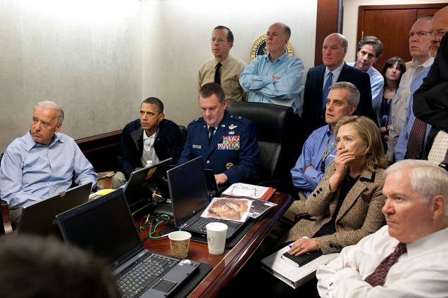 Time de Segurança Nacional dos Estados Unidos acompanha missão que prendeu e executou o terrorista Osama Bin Laden. As reuniões geralmente acontecem em salas maiores mas Obama escolheu esta sala menor e sentou ao lado do Brigadeiro Marshall Brad Webb, Comandante Geral da Unidade de Operações Especiais dos Estados Unidos