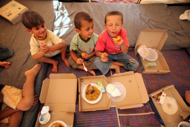 Garotos sírios recebem alimentos da ONU em acampamento na Jordânia (Foto Anadolu Ajansi/ Salah Malkawi/ ONU Divulgação)