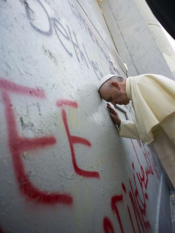 Papa desce do veículo, encosta a cabeça e reza no muro que separa Belém (Cisjordânia) de Jerusalém, construído pelos israelenses para conter - e conteve! -  o terror 