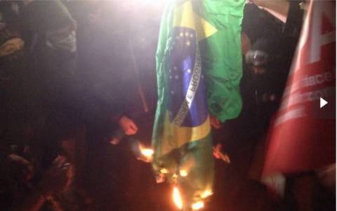 Bandeira do Brasil é queimada durante protesto contra a Copa (foto: Felipe Souza-Folhapress)