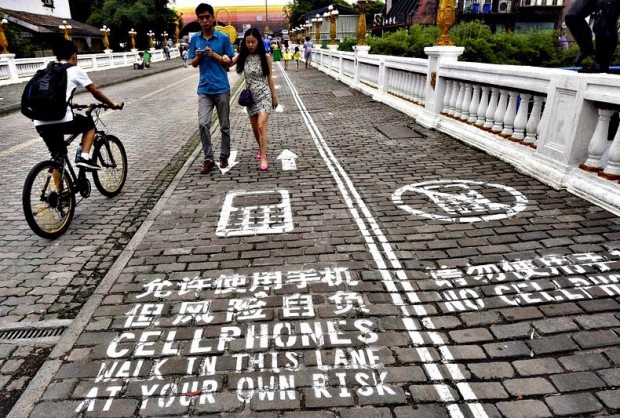Chineses criaram espaço exclusivo para  caminhar olhando para o smartphone. "Ande nesta faixa por seu próprio risco", diz o aviso