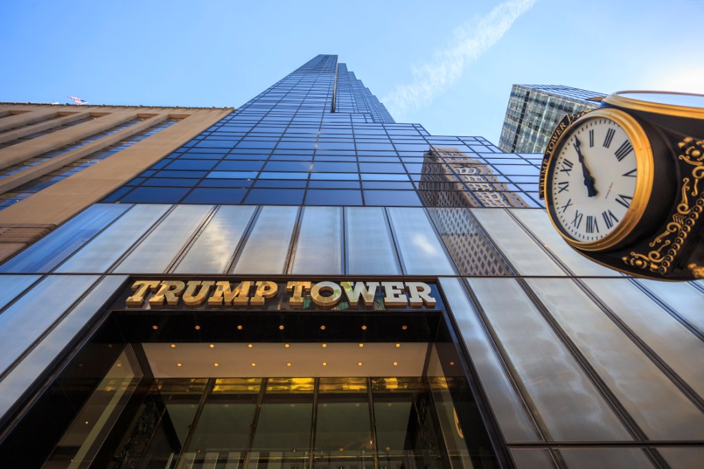 New York City, United States - March 12, 2016: Looking up at the 5th avenue Trump Tower with the gold name and clock in sight