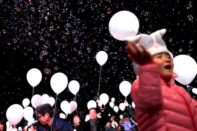 Japoneses celebram o ano novo com milhares de bolhas de sabão e balões brancos, pedindo paz, em Tóquio - 31/12/2016