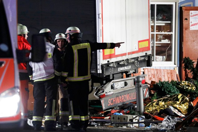 Bombeiro conversam ao lado do caminhão que invadiu uma feira de Natal em Berlim, na Alemanha - 19/12/2016