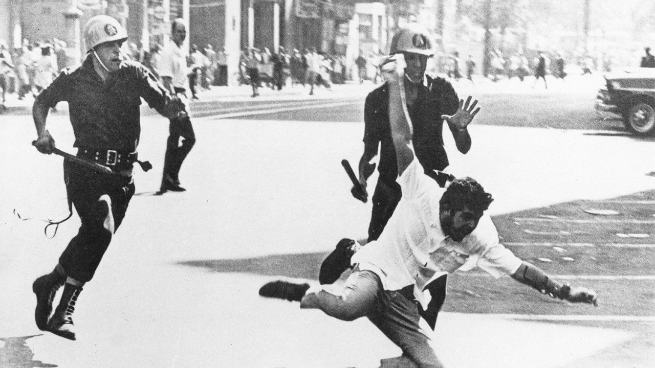 Estudante caindo no chão, durante perseguição policial aos manifestantes na Avenida Rio Branco - 1964