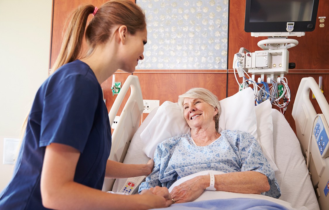 enfermeira conversando com paciente na cama do hospital