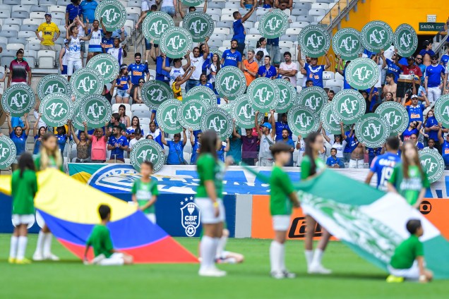 Torcedores do Cruzeiro seguram escudos com o símbolo da Chapecoense antes da partida contra o Corinthians, no Mineirão, em Belo Horizonte