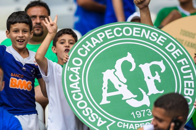 Torcedores do Cruzeiro seguram um escudo com o símbolo da Chapecoense antes da partida contra o Corinthians, no Mineirão, em Belo Horizonte