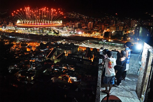 Moradores da favela da Mangueira assistem a queima de fogos, durante a cerimonia de abertura dos Jogos Olímpicos Rio-2016, no Estádio do Maracanã - 05/08/2016