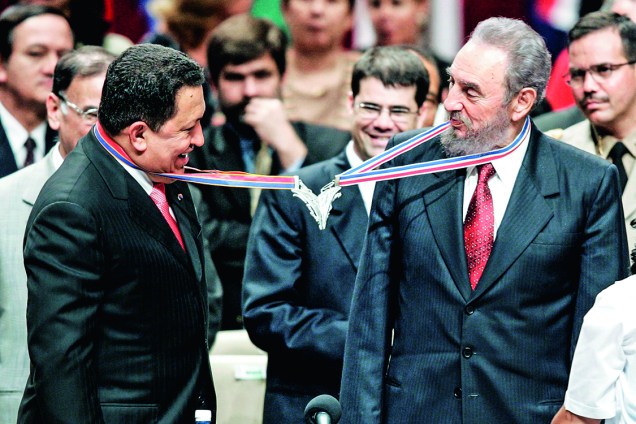 Enroscando medalhas com o presidente venezuelano Hugo Chávez, que deu petróleo a Cuba (Agosto, 2005)