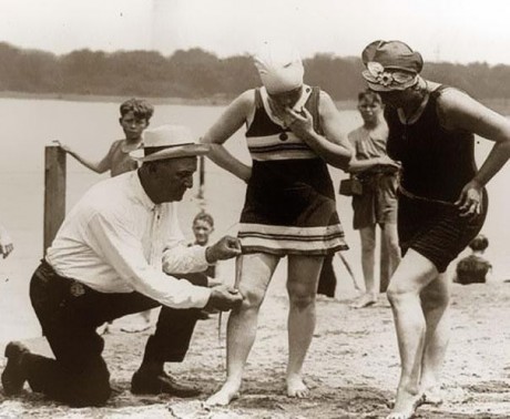 Fiscal medindo o comprimento do traje de banho das mulheres (1929)