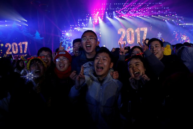 Pessoas posam para fotos enquanto participam de um evento de contagem regressiva de Ano Novo em Pequim, na China
