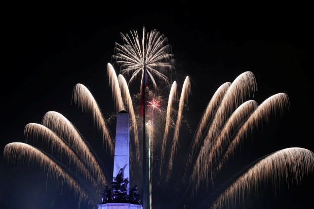 Fogos de artifício explodem atrás do monumento do herói nacional Jose Rizal durante celebrações do Ano Novo no parque de Luneta, metro Manila, nas Filipinas