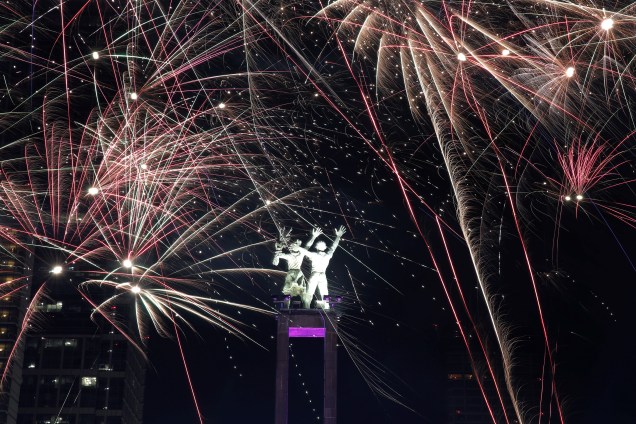 Fogos de artifício explodem em torno do monumento de Selamat Datang durante celebrações de Ano Novo em Jakarta, na Indonésia