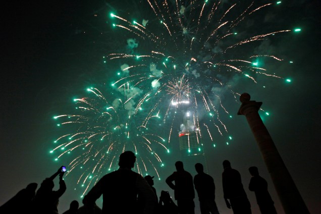 Pessoas se reúnem para observar fogos de artifício em comemoração do Ano Novo em Karachi, no Paquistão