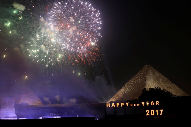 Fogos de artifício explodem acima das pirâmides durante celebrações de Ano Novo nos subúrbios da Cidade do Cairo, no Egito