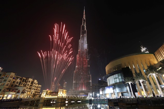 Fogos de artifício explodem ao redor no edifício o mais alto do mundo, Burj Khalifa, em Dubai durante as celebrações do Ano Novo
