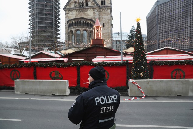 Policial faz segurança do lado de fora do mercado de Natal na Praça Breitscheid em Berlim, na Alemanha