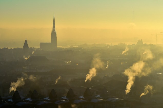 Fumaça sobe das chaminés enquanto a torre da igreja de Saint Michel é vista durante uma manhã fria na cidade francesa de Bordeaux - 02/12/2016