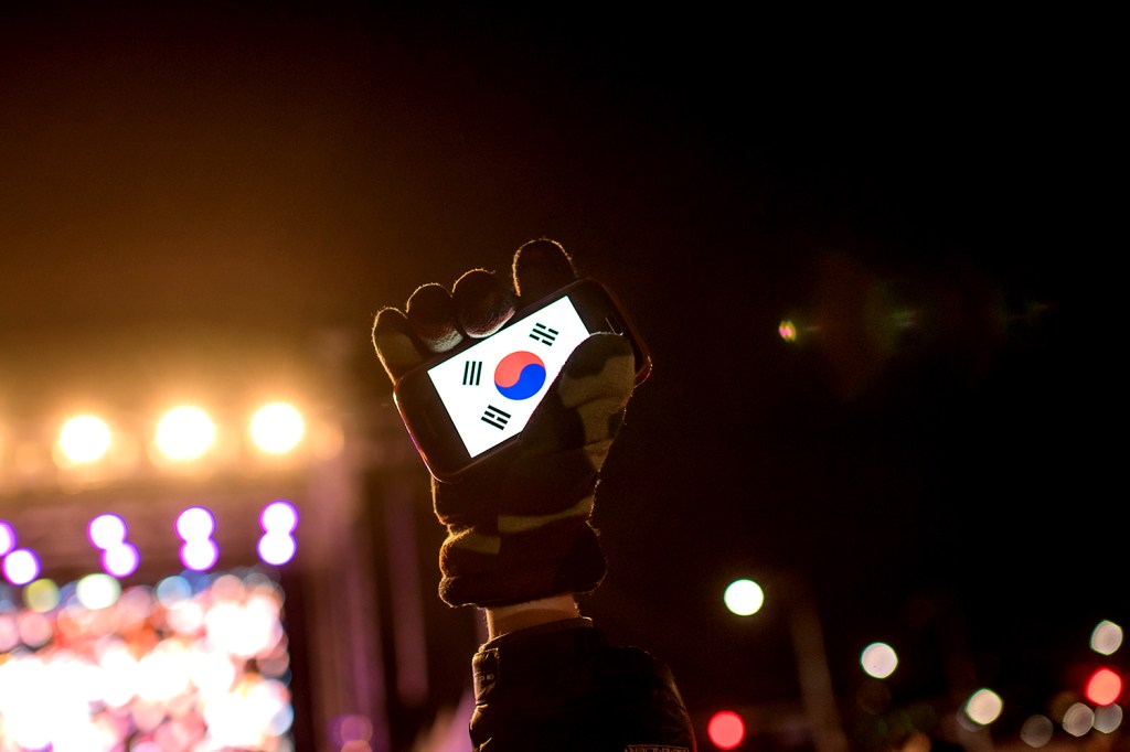Manifestante protesta a favor da deposição da Presidente da Coreia do Sul após escândalo de corrupção