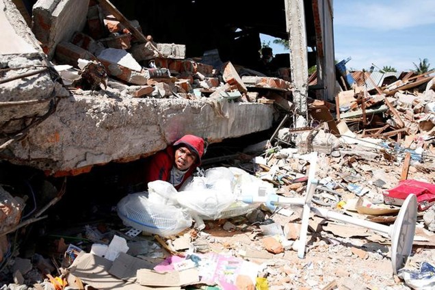 Homem em meio a destroços após terremoto em Pidie Jaya, Indonésia - 09/12/2016