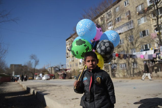 Menino vendedor de balões espera por clientes em Cabul, no Afeganistão - 06/12/2016