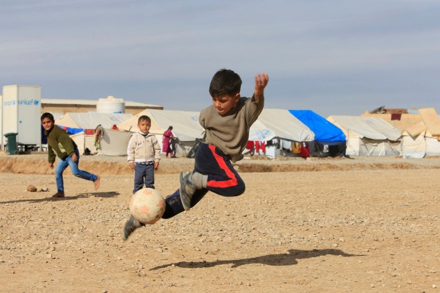 Crianças fugidas da violência do Estado islâmico em Mosul, jogam bola no campo de refugiados de Khazer, no Iraque - 05/12/2016