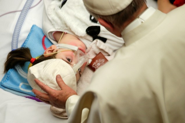 Papa Francisco oferece seu boné a uma criança doente durante uma audiência especial para pacientes e trabalhadores do hospital pediátrico Bambino Gesu, no Vaticano - 15/12/2016