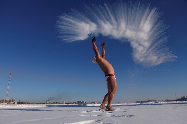 Homem joga água quente no ar frio em Heihe, província de Heilongjiang, na China