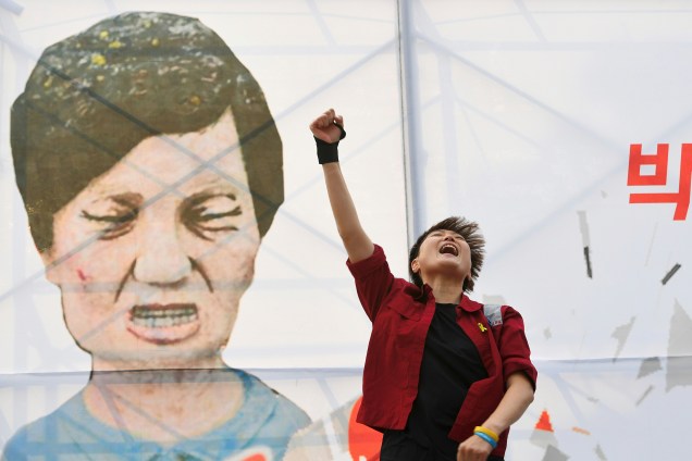 Manifestante grita palavras de ordem em frente a uma caricatura de Park Geun-Hye, durante protesto que pede o impeachment  da presidente da Coreia do Sul - 07/12/2016