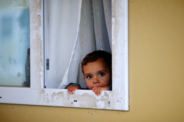 Garoto refugiado sírio olha por uma janela no acampamento de Elbeyli, em Kilis, próximo a fronteira entre Síria e Turquia - 01/12/2016