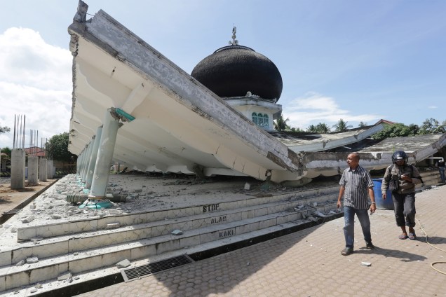 Pessoas ao redor de uma mesquita desmoronada após o terremoto em Meuredu, Pidie Jaya, na província de Aceh, na Indonésia - 07/12/2016