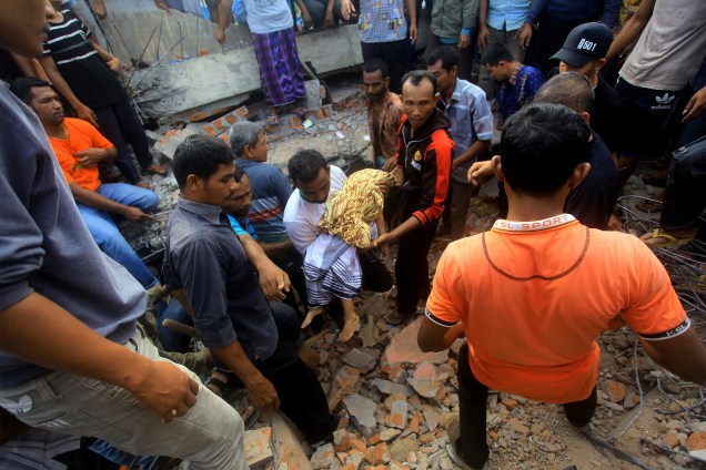 O corpo de uma criança é retirado dos escombros após terremoto que atingiu a província de Aceh, na ilha de Sumatra, na Indonésia - 07/12/2016