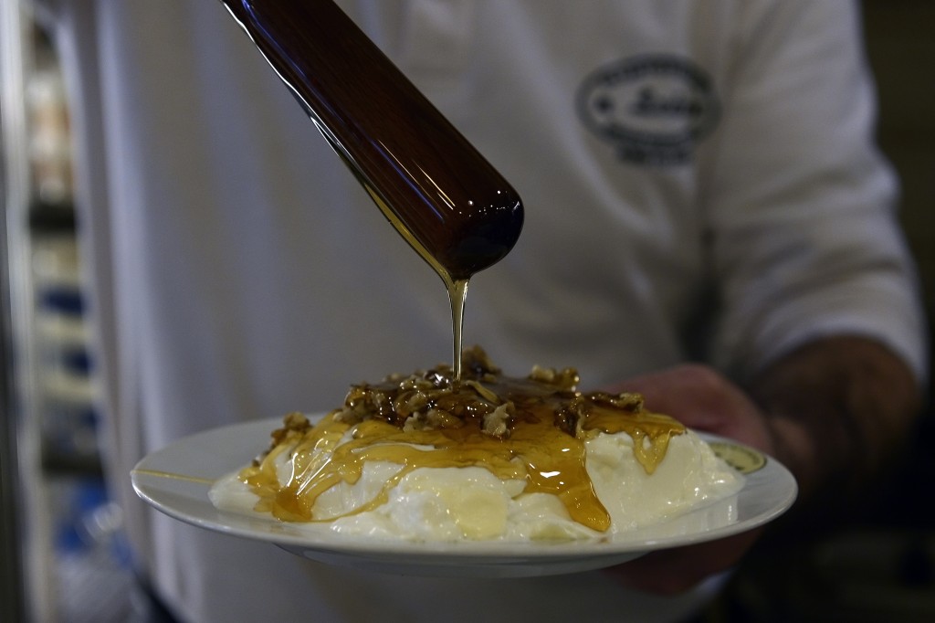 Cozinheiro serve iogurte com mel e nozes em restaurante de Atenas, em março de 2014. Crédito: Aris Messinis, AFP