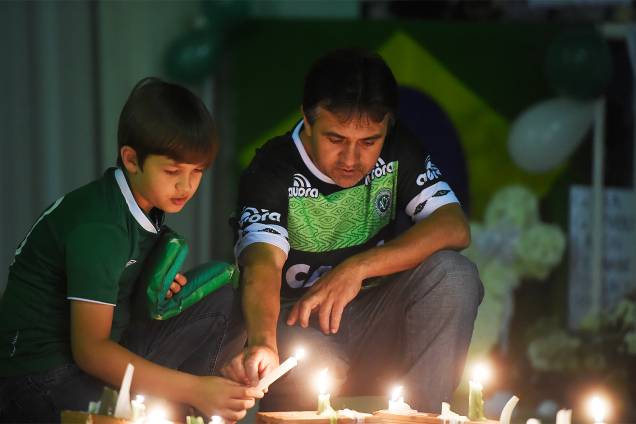 Pai e filho acendem velas em homenagem às vítimas do acidente de avião da Chapecoense