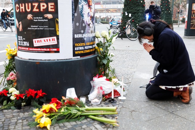 Mulher reza próximo do local onde caminhão avançou sobre multidão e matou 12 pessoas, em Berlim, na Alemanha - 20/12/2016