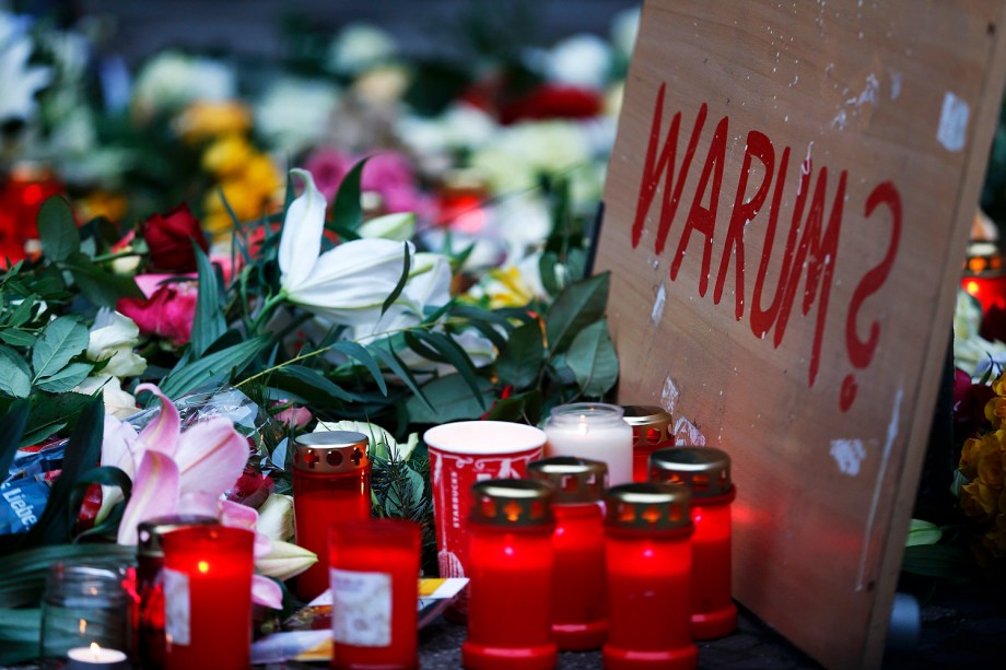 Pessoas colocam flores próximas do local onde caminhão avançou sobre multidão e matou 12 pessoas, em Berlim, na Alemanha - 20/12/2016