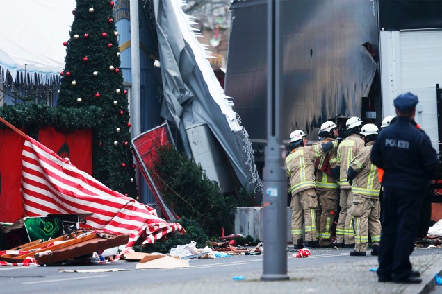Policiais e bombeiros verificam danos causados em uma feira natalina, após caminhão avançar sobre multidão em Berlim, na Alemanha - 20/12/2016