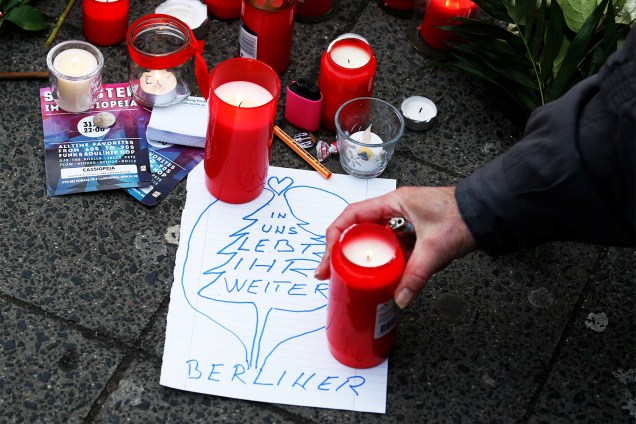 Homem acende velas em memória às vítimas do ataque em uma feira natalina, em Berlim, na Alemanha - 20/12/2016