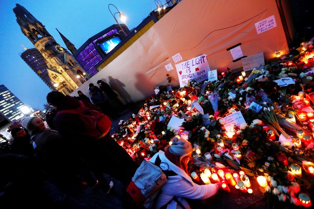 Pessoas colocam flores próximas do local onde caminhão avançou sobre multidão e matou 12 pessoas, em Berlim, na Alemanha - 20/12/2016