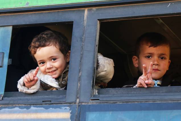 Crianças sírias são fotografadas em ônibus ao serem evacuadas da região de Khan al-Aassal, no oeste de Alepo - 15/12/2016