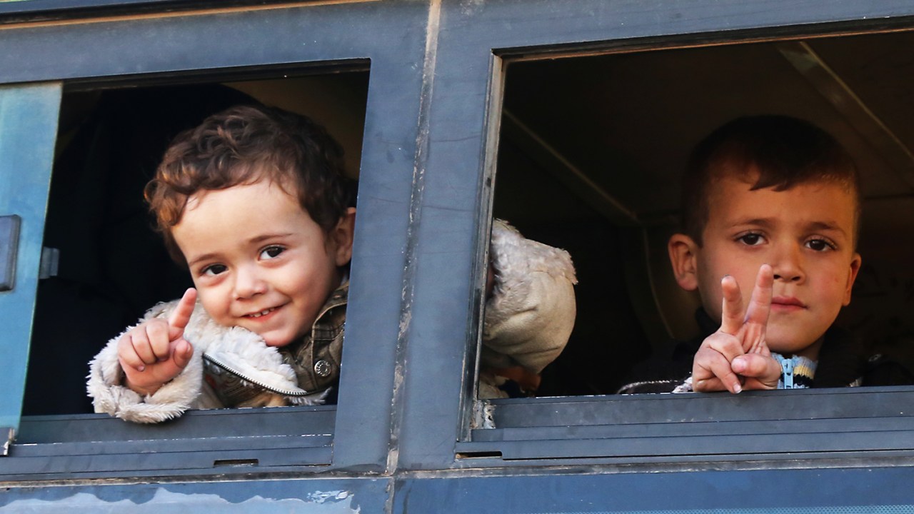 Crianças sírias são fotografadas em ônibus ao serem evacuadas da região de Khan al-Aassal, no oeste de Alepo - 15/12/2016