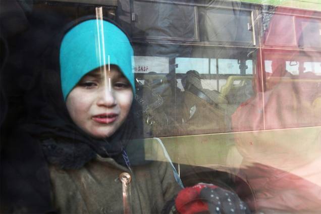 Garota é vista em ônibus durante evacuação de moradores de área rebelde no leste de Alepo - 18/12/2016