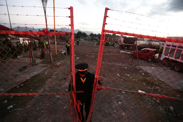 Guarda fecha portão próximo ao local onde houve explosão de fogos de artifício, em Tulpetec, na Cidade do México. Ao menos 31 pessoas morreram e outras 72 ficaram feridas - 21/12/2016