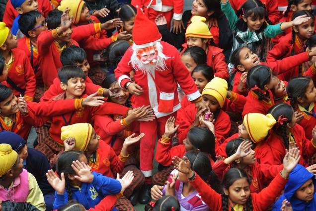 Papai Noel brinca com estudantes enquanto distribui doces em uma escola de Amritsar, na Índia - 24/12/2016