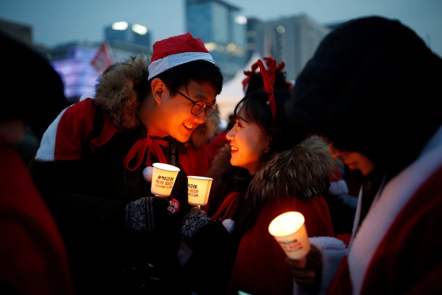 Casal com com trajes natalinos durante protesto que pede a renúncia da presidente sul-coreana Park Geun-hye, em Seul - 24/12/2016