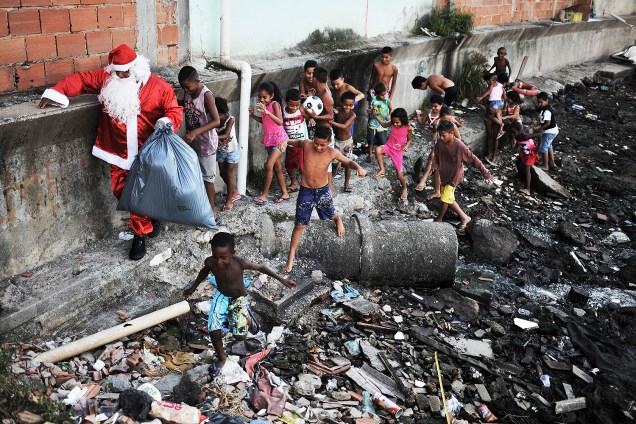 Homem vestido de Papai Noel visita a favela da Maré, na zona norte do Rio de Janeiro - 24/12/2016