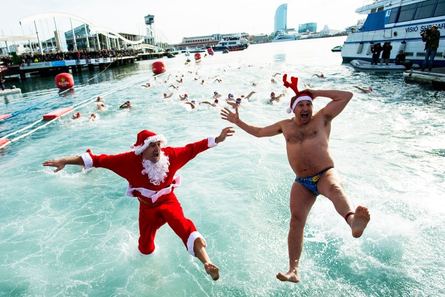 Participantes vestidos de Papai Noel pulam na água durante a 107ª edição da Copa Nadal (Copa de Natal) em Barcelona, na Espanha. O tradicional evento reuniu cerca de 400 participantes no antigo porto da cidade - 25/12/2016